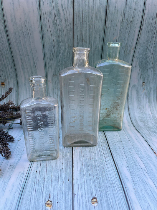 Three Vintage Clear Medicine Bottles with Teaspoon and Tablespoon Measures